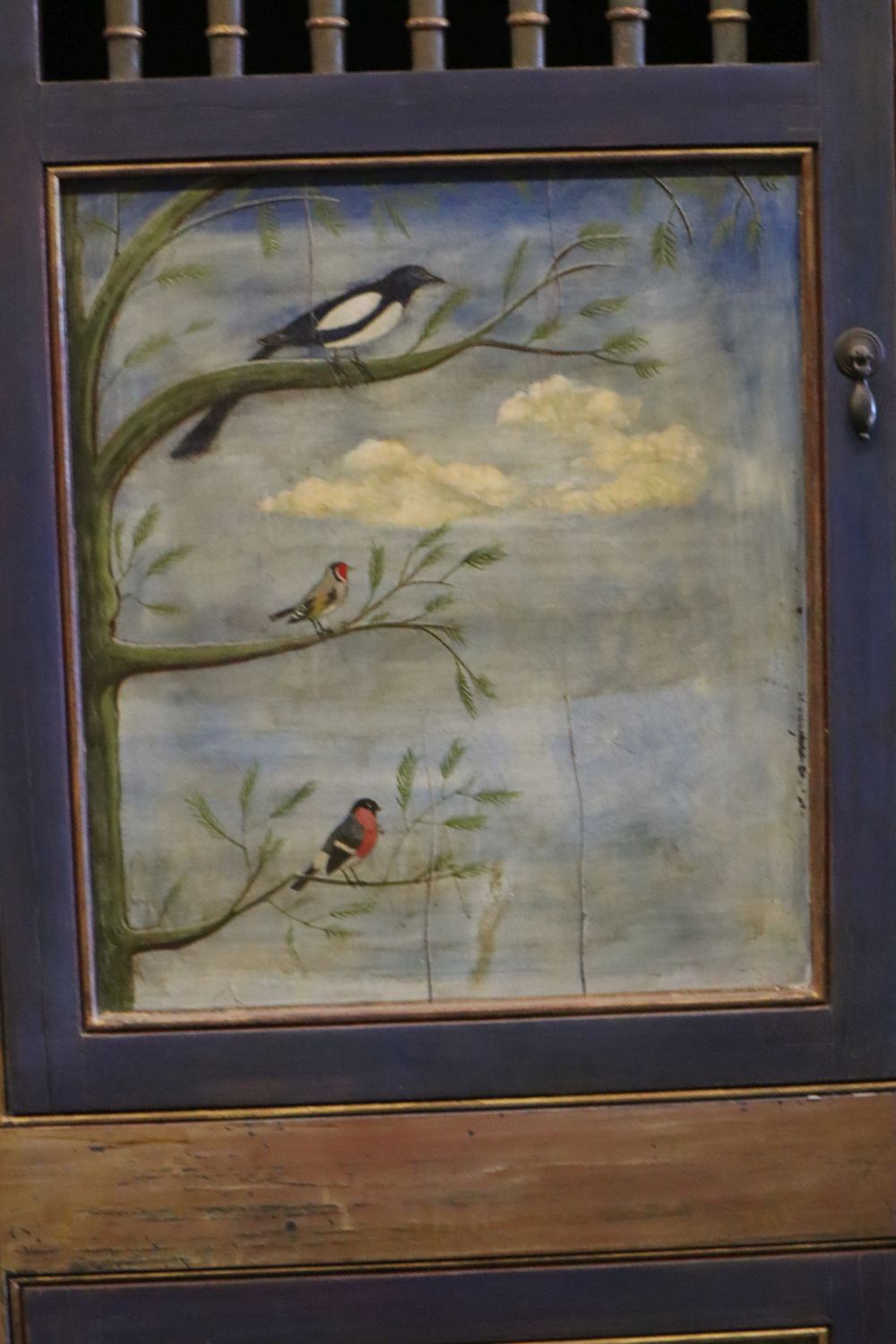 A 19th century Continental painted armoire, later decorated with birds on branches, rabbits and fish, the top two doors each enclosing